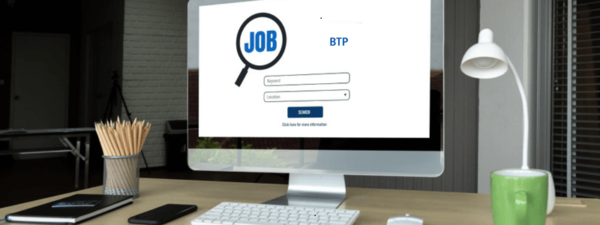 Bureau avec un ordinateur affichant 'BTP', représentant les recherches d'emploi dans le BTP