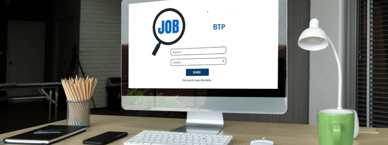 Bureau avec un ordinateur affichant 'BTP', représentant les recherches d'emploi dans le BTP