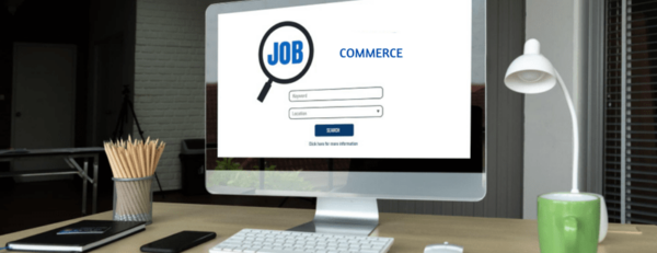 Bureau avec un ordinateur affichant 'Commerce', représentant les recherches d'emploi dans le commerce