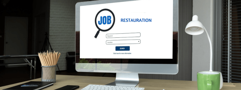 Bureau avec un ordinateur affichant 'Restauration', représentant les recherches d'emploi dans la restauration